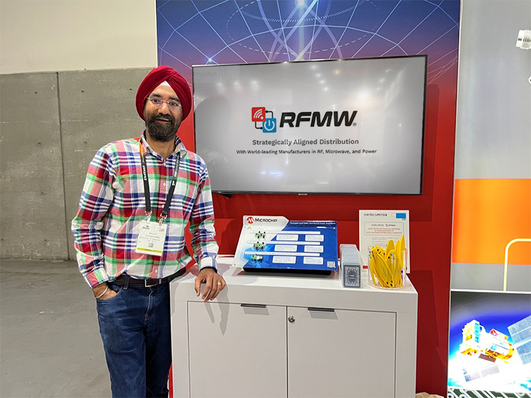 Microchip Product Management Executive Baljit Chandhoke stands next to the Microchip product display at the RFMW booth at IMS 2023